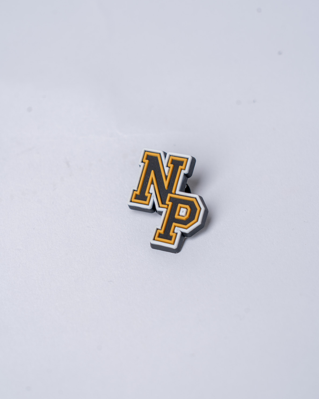 The Panthersland Nottingham Panthers 25-26 NP Croc Charm features bold yellow uppercase NP letters outlined in black and white, set against a plain light gray background.