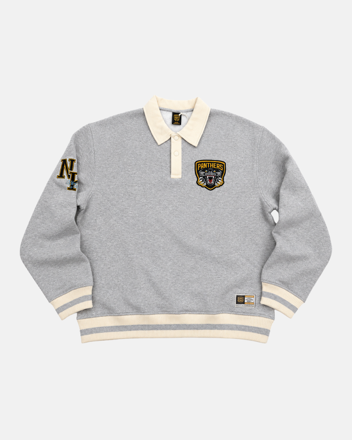 The Panthersland 26-27 Grey Crest Sweater is a light gray long-sleeve rugby-style sweater featuring a cream collar and cuffs, the iconic Panthers crest on the chest, N and T letters on the left sleeve, and a small rectangular label near the hem for classic appeal.