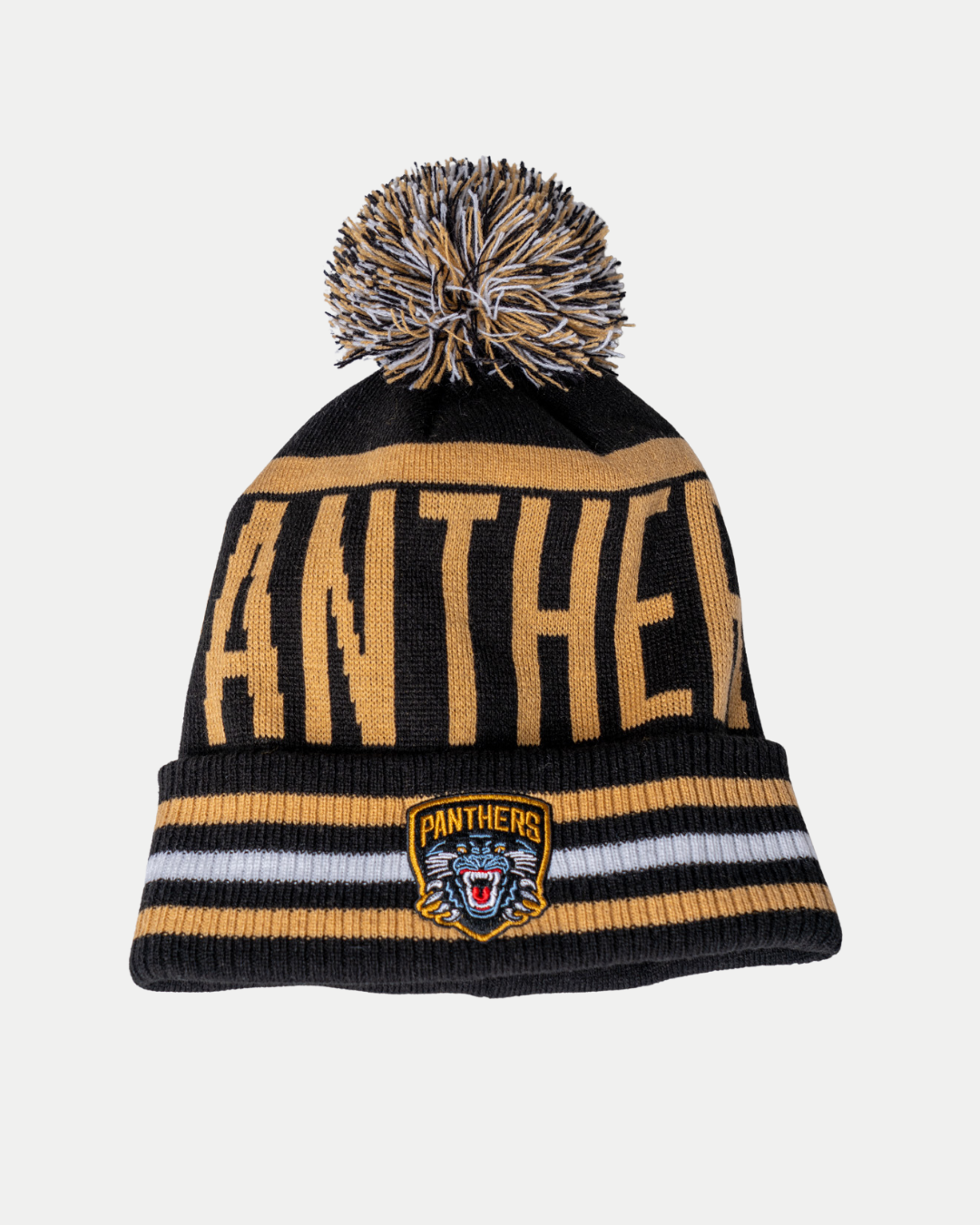 The Panthersland Nottingham Panthers 25-26 CCM Black Gold Pom Knit is a black and gold beanie with a pom-pom, "PANTHERS" text, a panther logo patch on the front, and two gold stripes above the brim.