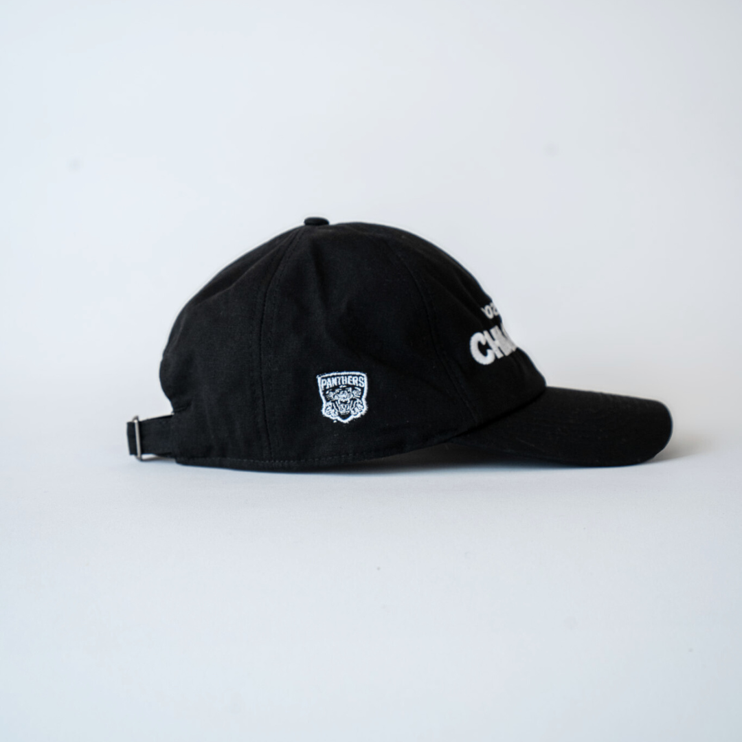 The Nottingham Panthers Made To Order Playoff Champions Panthers 2025 Organic Cotton Dad Cap in black & white features a small logo on the side and is displayed on a plain white background. This eco-friendly cap is perfect for fans.
