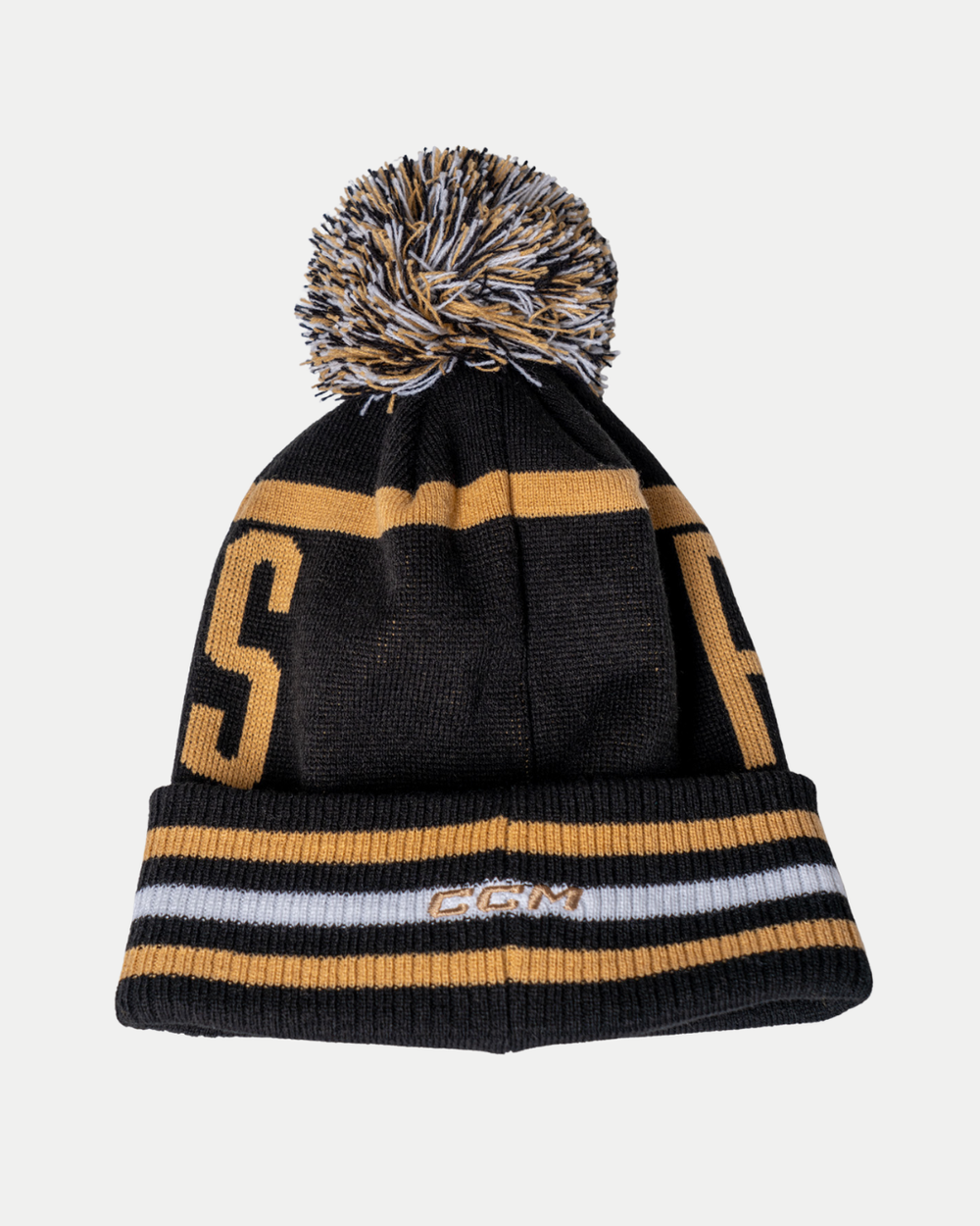 The Panthersland Nottingham Panthers 25-26 CCM Black Gold Pom Knit is a black beanie with gold and white stripes, a top pom-pom, and “CGM” embroidered on the folded brim.