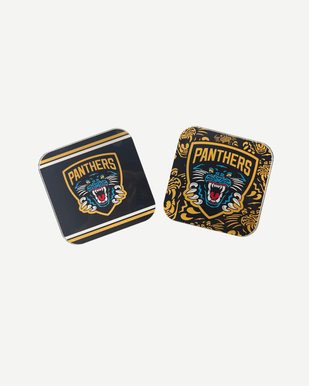 The Panthersland Nottingham Panthers Coaster Twin Pack includes two square coasters—one with a striped border, one with a gold floral design—both featuring the fierce team logo and "Panthers" text. Perfect for showing your team pride.