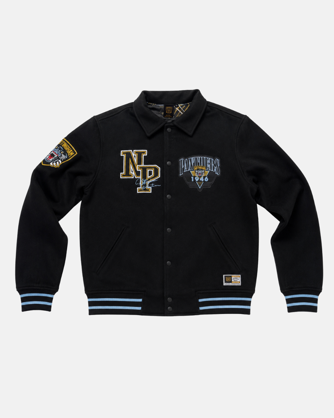 The Panthersland 26-27 Vintage Varsity Jacket is a black, vintage-inspired piece featuring blue and gold patches—such as “NP,” a distinctive Panthers crest with “Panthers 1994,” and a shield motif on the sleeve. This jacket is finished with blue-striped cuffs and hem, classic button closure, and two front pockets.