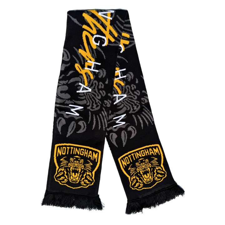 The Panthersland 25-26 Signature Scarf is black with fringed ends, yellow and white NOTTINGHAM text, the Nottingham Panthers’ roaring tiger logo, crests, and a subtle dark pattern in the background.