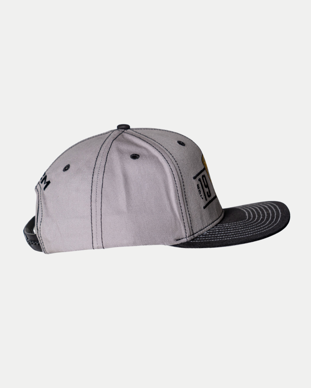 A side view of the Panthersland Nottingham Panthers 25-26 CCM Grey Flat Brim Snapback with a black flat brim, black stitching, a small rectangular side logo, and an adjustable snapback strap.