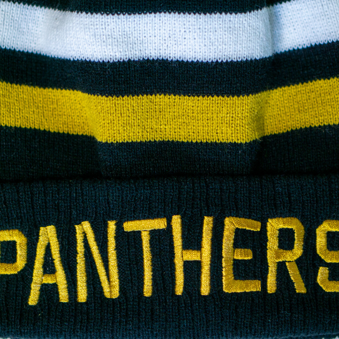 A close-up of the Panthersland Nottingham Panthers 25-26 White Stripe Pom Knit beanie, featuring black, white, and yellow stripes with PANTHERS embroidered in yellow—ideal as a cozy winter accessory for Panthers fans.