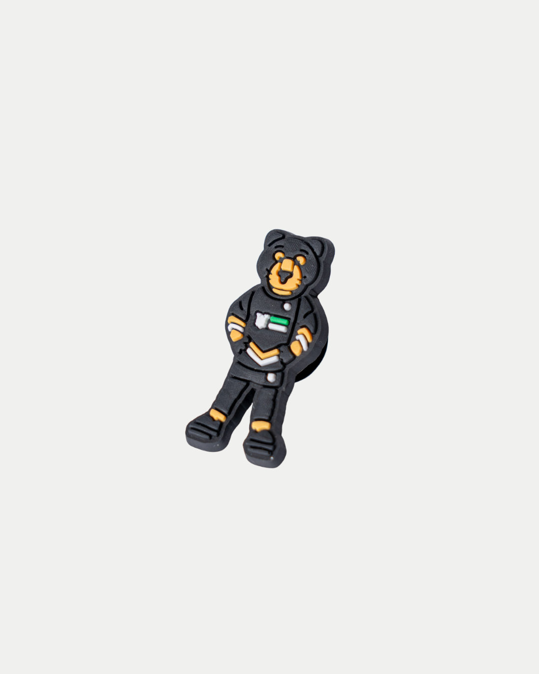 The Panthersland Paws Croc Charm is a rubber bear mascot in a black outfit with orange accents and a mini Nottingham Panthers flag on its chest, perfect for accessorizing Crocs. Shown on a plain white background.