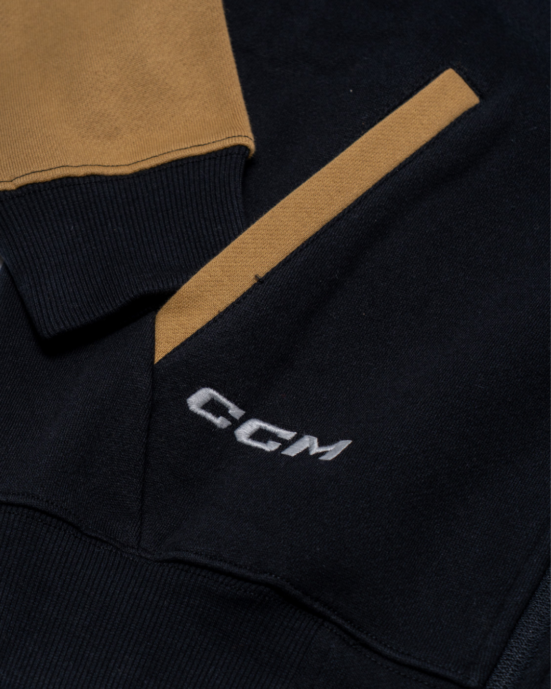 Close-up of the Nottingham Panthers 25-26 CCM Track Jacket by Panthersland, featuring tan pocket and sleeve accents on a dark base. "CGM" is embroidered in white near the pocket.