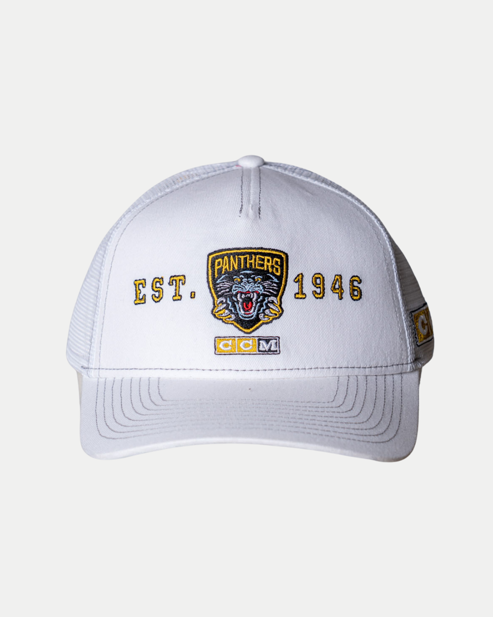 The Panthersland Nottingham Panthers 25-26 CCM White Mesh Back Trucker features EST. 1946, a panther logo, PANTHERS, and CCM embroidered in yellow, black, and white on the front, with mesh sides and back for breathability.