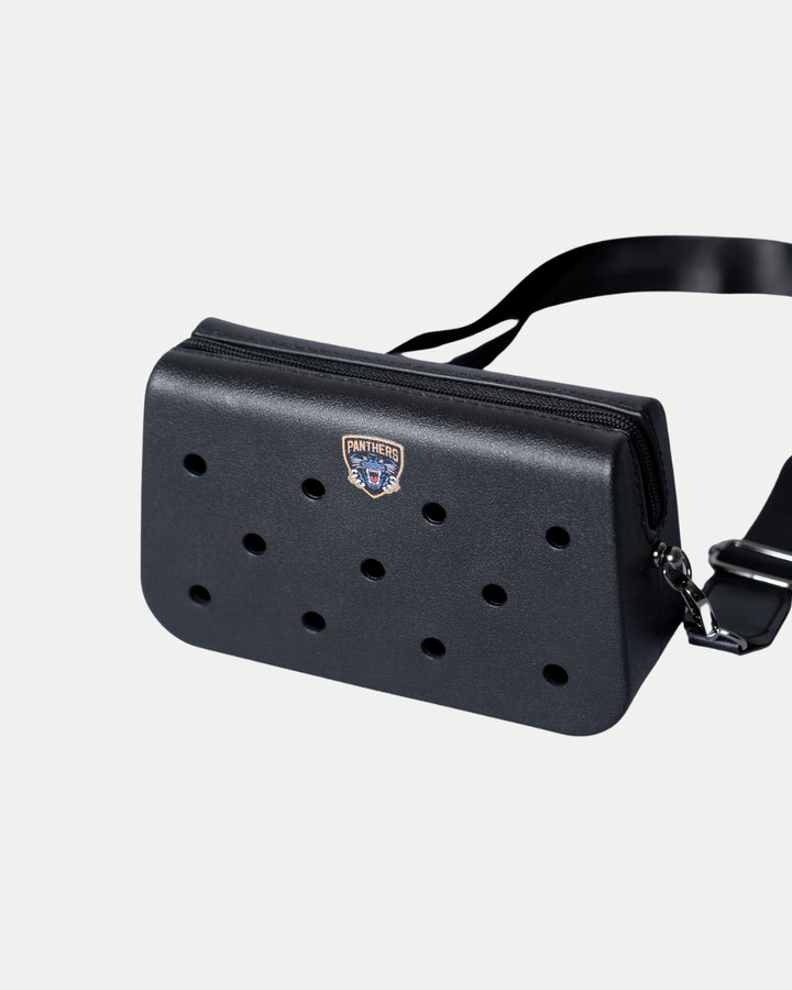 A rectangular black Nottingham Panthers Croc Charm Bag by Panthersland featuring round front holes, a zippered top, an adjustable strap, and a Nottingham Panthers hockey team logo badge.