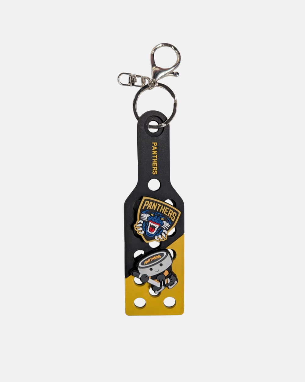 Show off your Panthers pride with the Nottingham Panthers Croc Charm Keyring from Panthersland. This keyring features a vibrant yellow and black design, including a rugby ball, cartoon panther mascot, the word “PANTHERS,” and the Nottingham Panthers team logo. It comes complete with a sturdy metal clasp at the top for easy attachment.