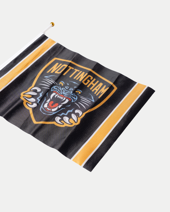Show your team spirit with the Panthersland Nottingham Panthers 25-26 Mini Flag, featuring a roaring panther logo, black and gold crest, gold and white stripes, "NOTTINGHAM" in bold yellow letters, and attached to a white pole—ideal for hockey fans!.