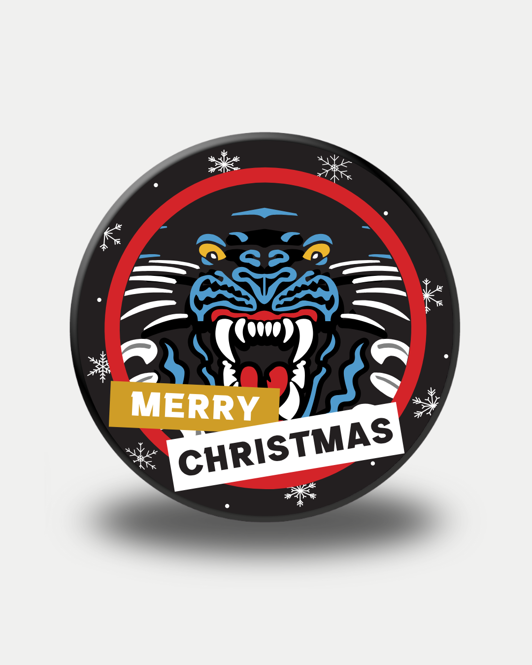 The Panthersland Nottingham Panthers 25-26 Christmas Puck Crest features a circular badge with a roaring black panther face, snowflakes, a red border, and "Merry Christmas" banners across the front.