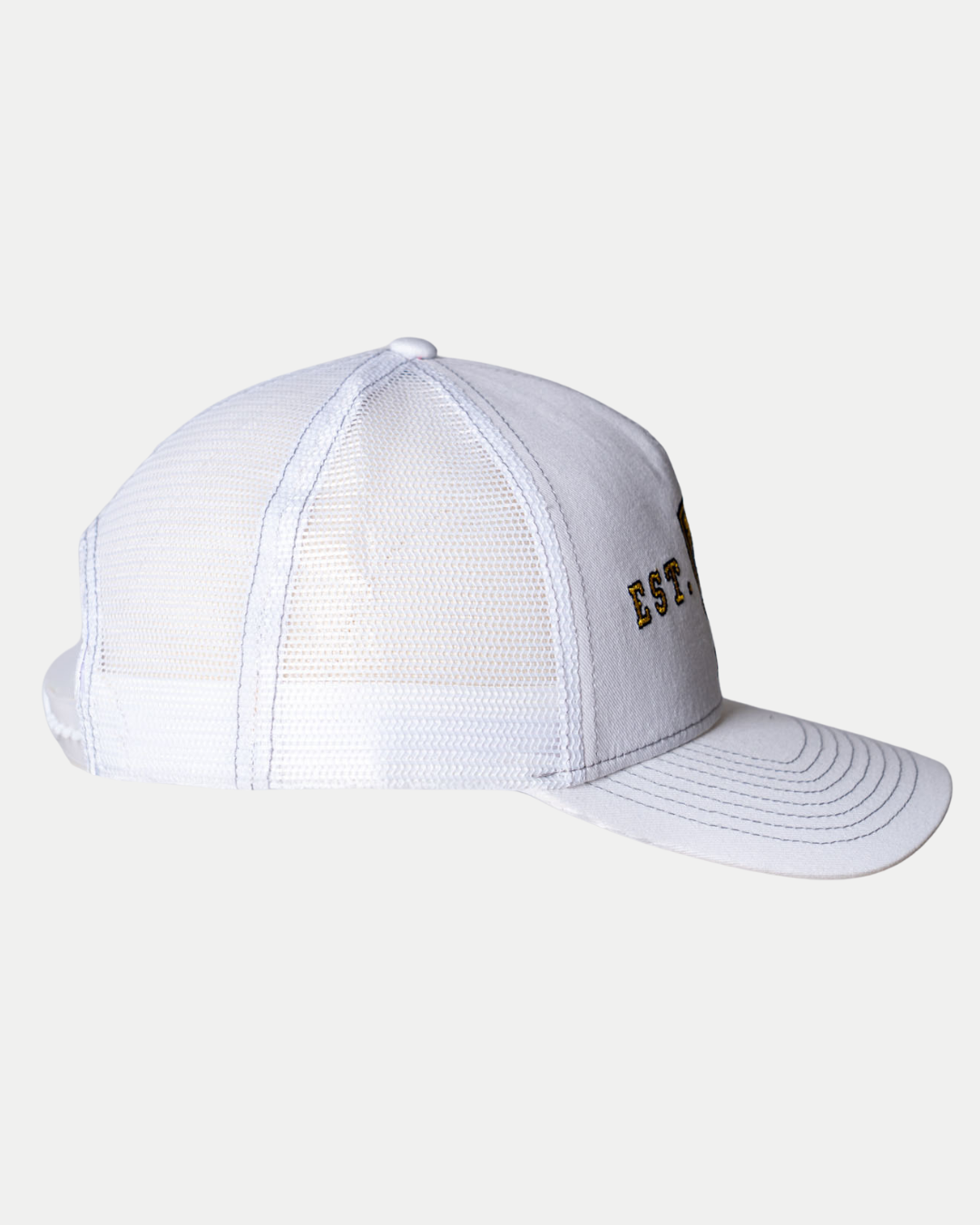 A side view of the Panthersland Nottingham Panthers 25-26 CCM White Mesh Back Trucker shows a light gray mesh trucker hat with a curved brim and partially visible black and gold embroidered text on the front panel.