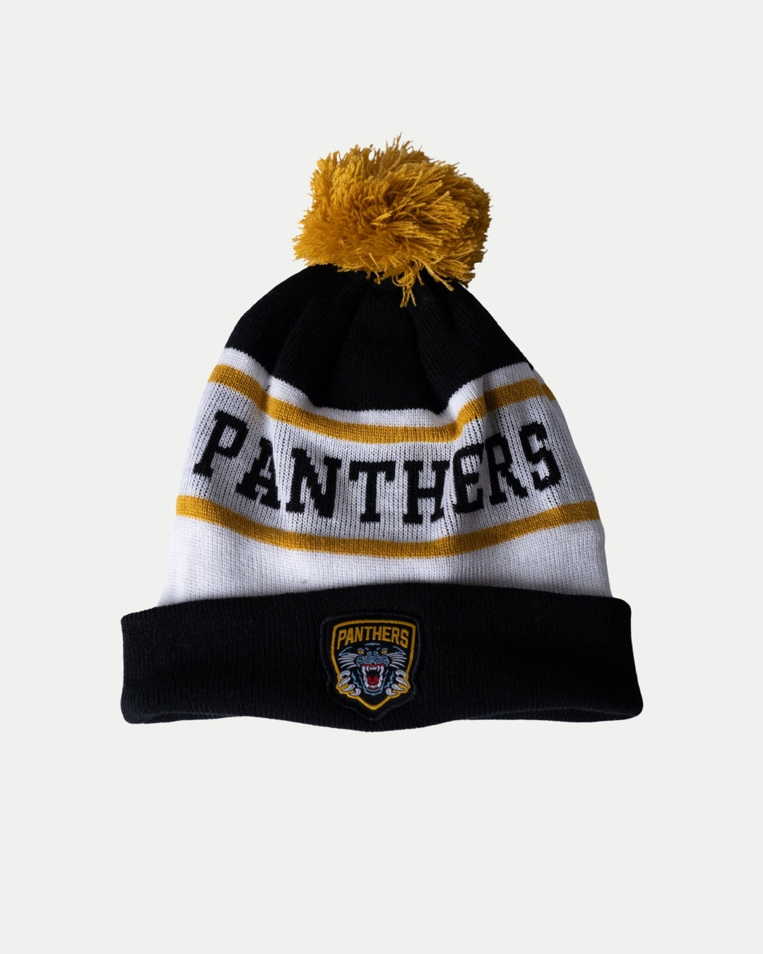 The Nottingham Panthers White Team Pom Knit is a cozy beanie in black, white, and yellow with a pom-pom, PANTHERS stitched on the front, and a panther head logo patch with PANTHERS on the turned-up brim.