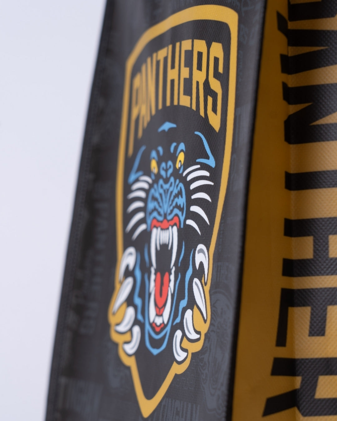 A Small Reusable Tote Bag by The Nottingham Panthers showcasing a roaring panther logo with PANTHERS in bold yellow above it on a striking black and gold background.