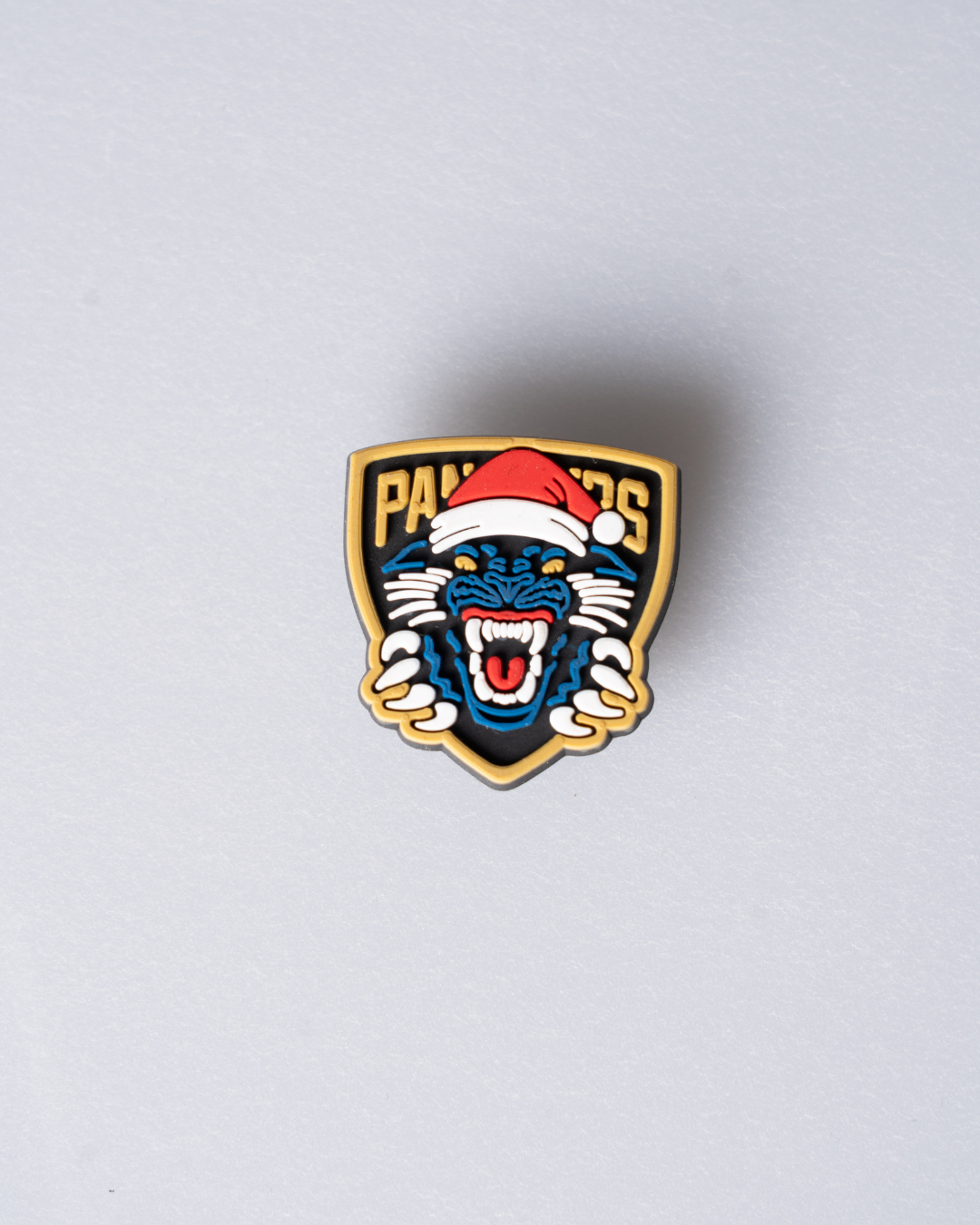 The Panthersland Nottingham Panthers Santa Crest Croc Charm features a festive logo with a panther in a red and white Santa hat, making it perfect for the holidays. The charm stands out on a light gray background.