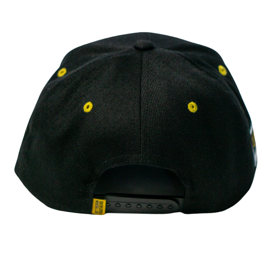 The Panthersland Nottingham Panthers 25-26 Script Snapback Cap features a black design, yellow stitched eyelets, gold embroidery for the team, and an adjustable plastic strap at the back.