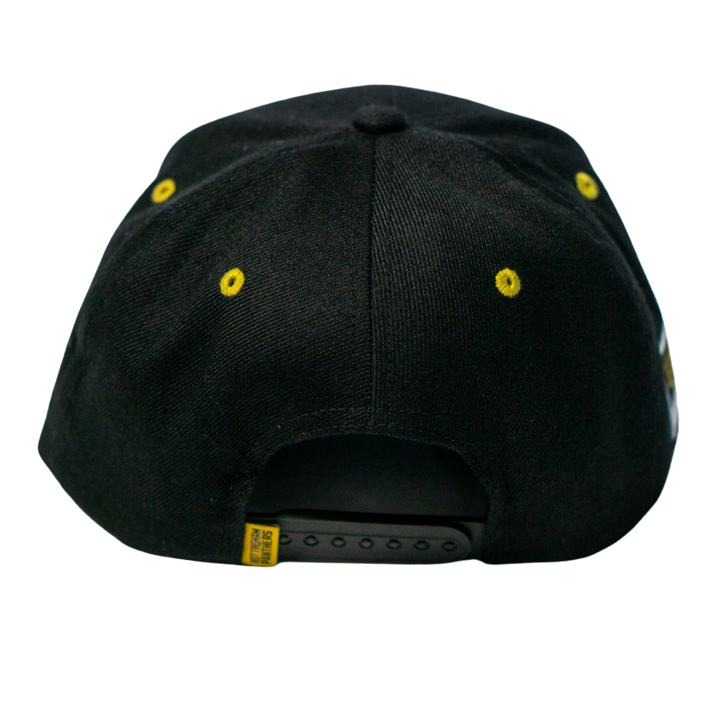 The Panthersland Nottingham Panthers 25-26 Script Snapback Cap features a black design, yellow stitched eyelets, gold embroidery for the team, and an adjustable plastic strap at the back.