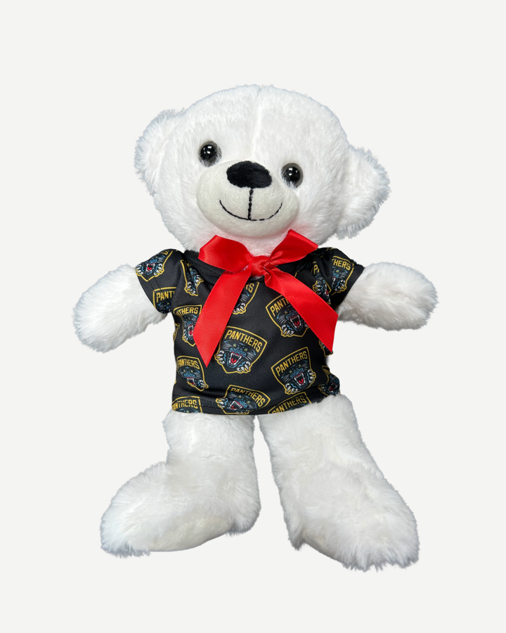 White teddy bear wearing a black shirt with panther logo and red bow tie on a white background