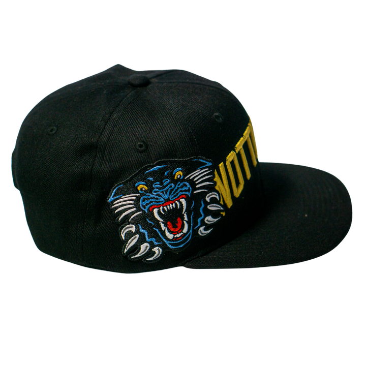 The Panthersland Nottingham Panthers 25-26 Big City Text Snapback Cap is a black cap with an embroidered blue, black, and white roaring panther and bold yellow VOTTO text on the side—ideal for fans and snapback collectors.