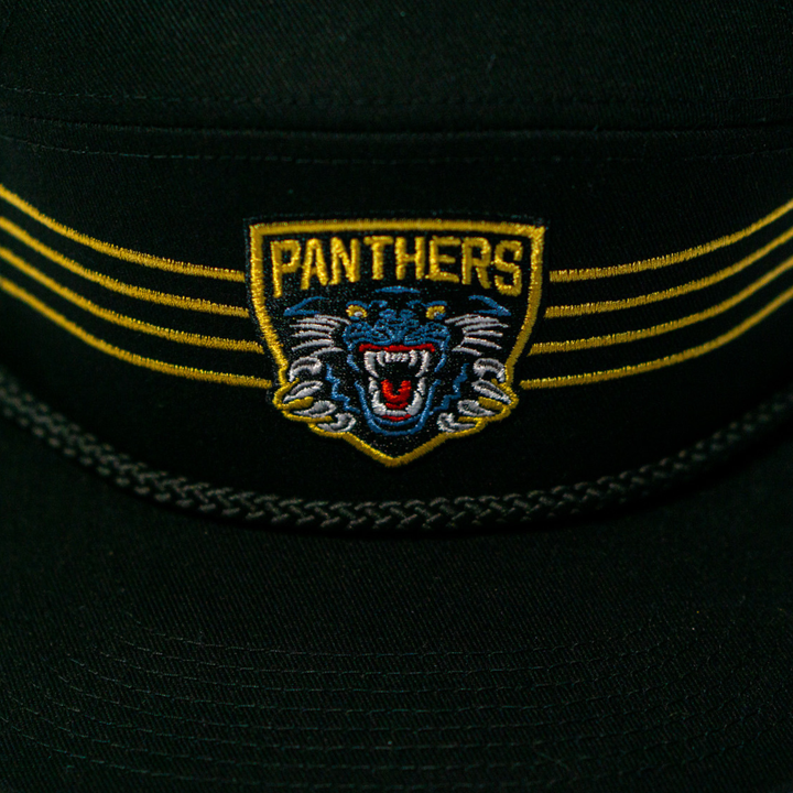 The Panthersland Nottingham Panthers 25-26 Four Stripe Flatbrim Cap is black with a yellow and blue embroidered crest showing a roaring panther and “PANTHERS” above it, plus bold gold stripes flanking the badge.