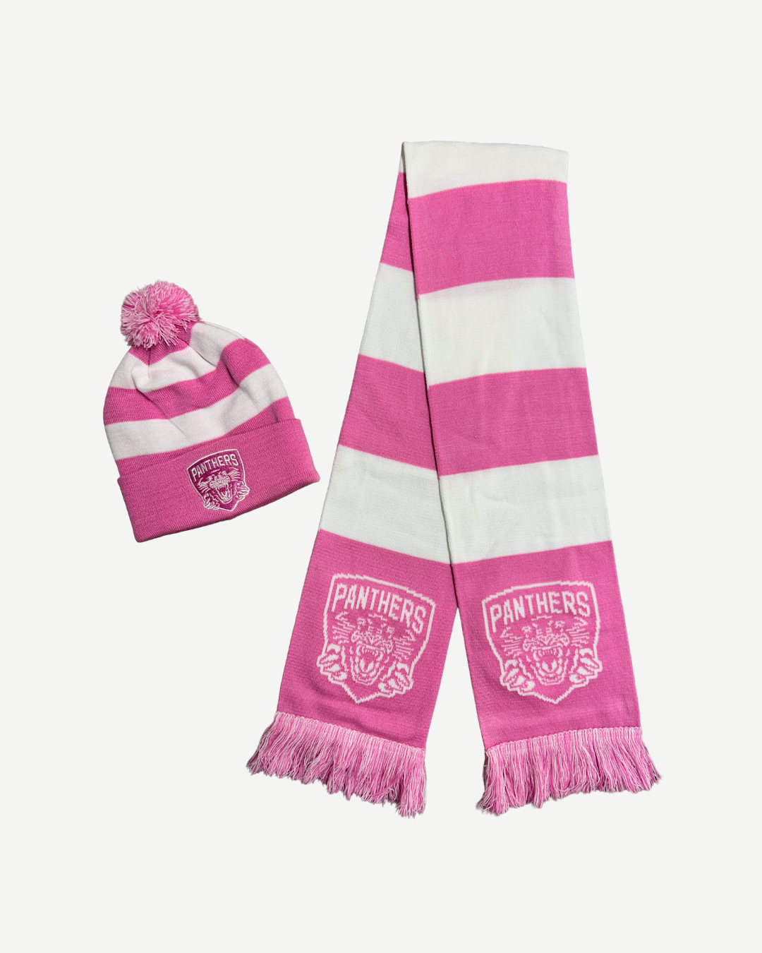 The Panthersland Nottingham Panthers Junior Hat & Scarf Set Pink features a pink and white striped beanie with a pom-pom and a matching fringed scarf, both displaying the Panthers logo with a panther head.