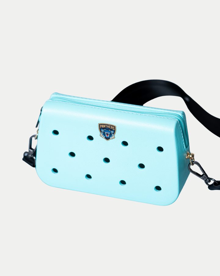 The Nottingham Panthers Croc Charm Bag by Panthersland is a small, light blue rectangular bag with a black strap, multiple round holes on the front, and a Panther patch logo above the holes, shown on a white background.