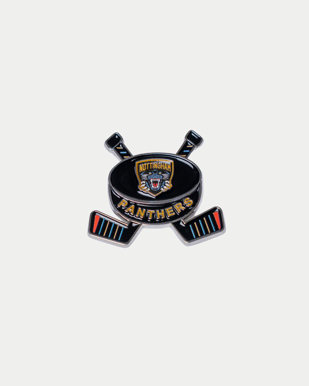 The Panthersland Nottingham Panthers Puck and Stick Pin Badge features the team logo on a puck, with two crossed, striped hockey sticks below.