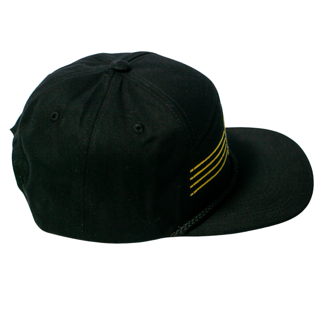 The Nottingham Panthers 25-26 Four Stripe Flatbrim Cap by Panthersland features a black design with four horizontal gold stripes on the front and a braided black band above the brim.