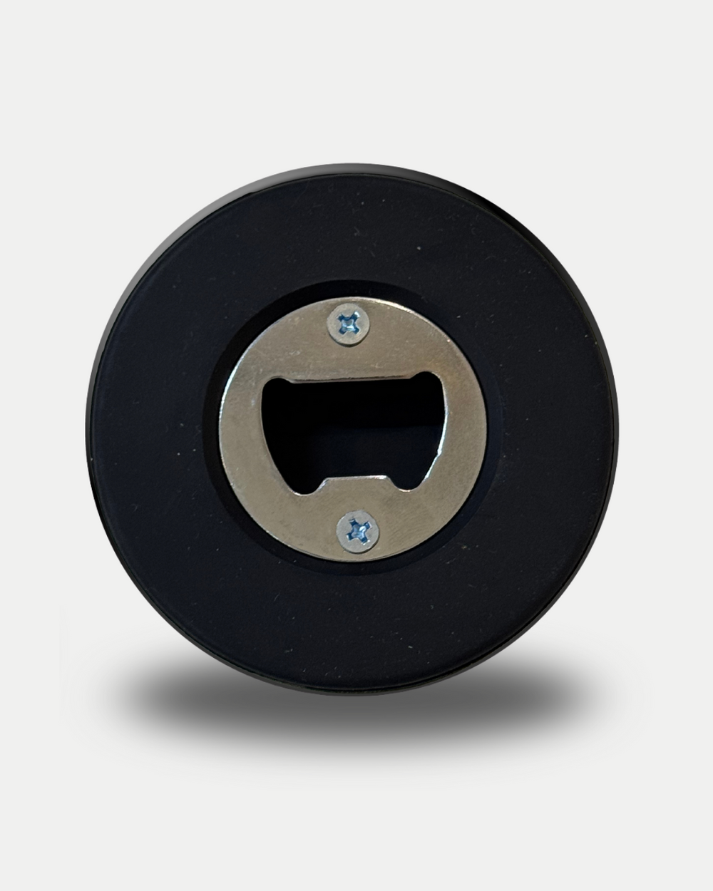The Panthersland Puck Bottle Opener is a round, black accessory featuring a metal bottle opener at its center, shown from above on a light background with a soft shadow.