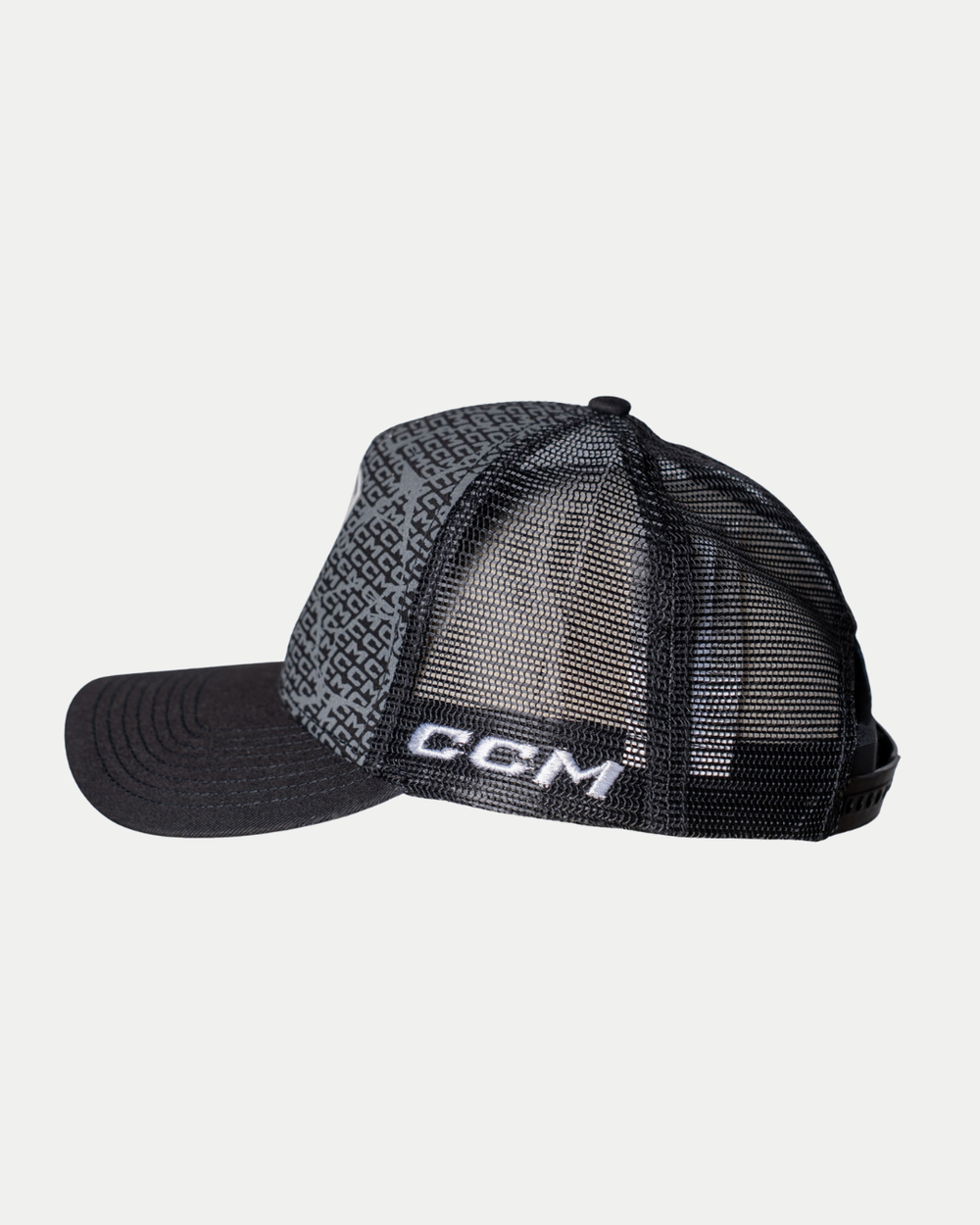The Panthersland Nottingham Panthers 25-26 CCM Black Mesh Back Trucker features a black mesh back, patterned fabric front panel, curved brim, and CGM embroidered in white on the side. The hat is shown against a plain white background.