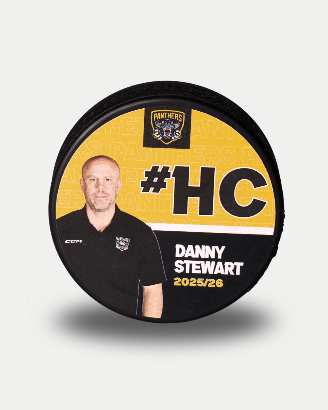 The 2025-26 Panthers Player Pucks by Nottingham Panthers is a limited edition ice hockey puck featuring a man in a black shirt, #HC, and "Danny Stewart 2025/26" on a black and yellow background—ideal for collectors.