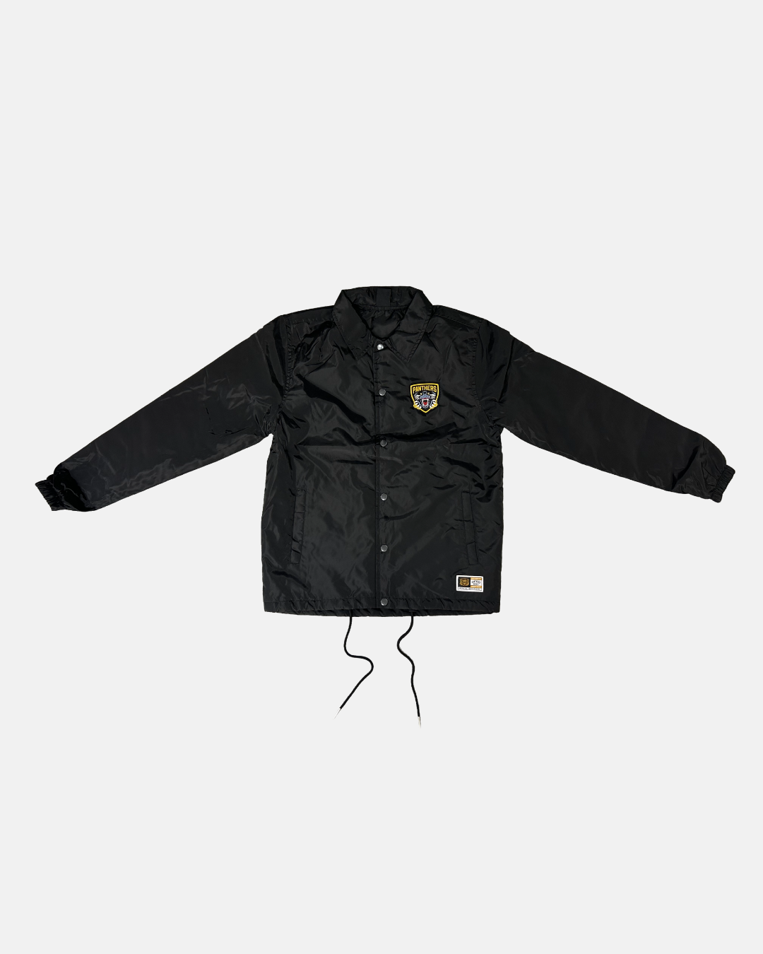 The Panthersland 26-27 Slice Coach Jacket is a black long-sleeve jacket featuring front buttons, two pockets, and a small yellow and white Nottingham Panthers silicone crest on the left chest. Drawstrings hang from the bottom hem, and the jacket is displayed laid flat on a white background.