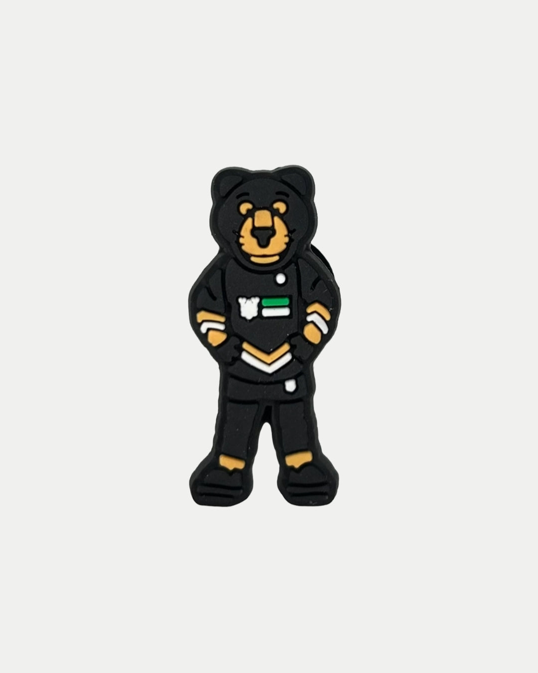 The Panthersland Paws Croc Charm is a cartoon bear figurine with orange accents and a black outfit with white and green details—perfect as a mascot charm for Nottingham Panthers fans or to decorate your Crocs.
