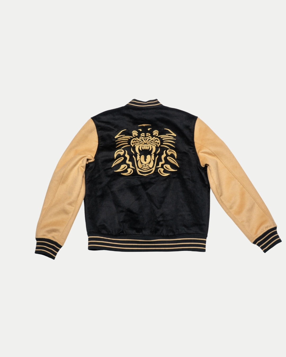 The Panthersland Nottingham Panthers Varsity Jacket Black/Gold 25-26 features striped cuffs and waistband, plus a large embroidered gold roaring tiger on the back.