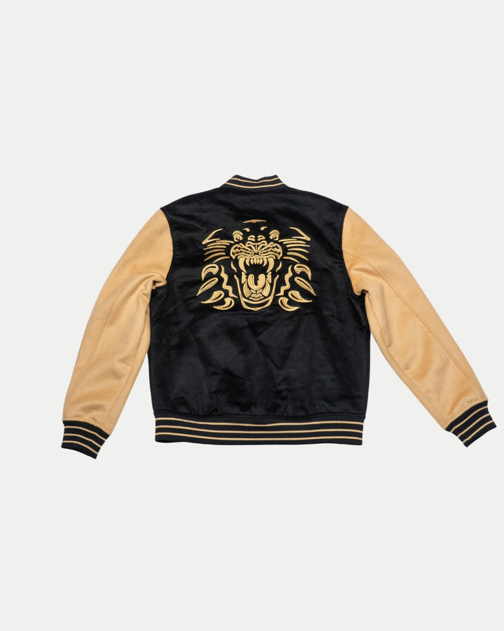 The Panthersland Nottingham Panthers Varsity Jacket Black/Gold 25-26 features striped cuffs and waistband, plus a large embroidered gold roaring tiger on the back.