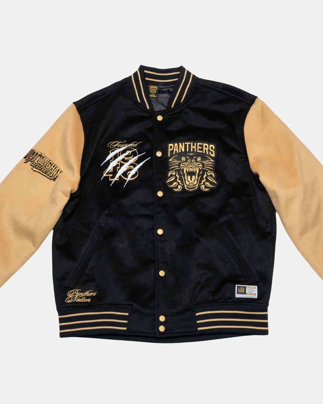 The Panthersland Nottingham Panthers Varsity Jacket Black/Gold 25-26 features PANTHERS and a roaring panther on the chest, gold buttons, tan sleeves, striped cuffs, bold patches, and white signatures—an iconic fan piece.