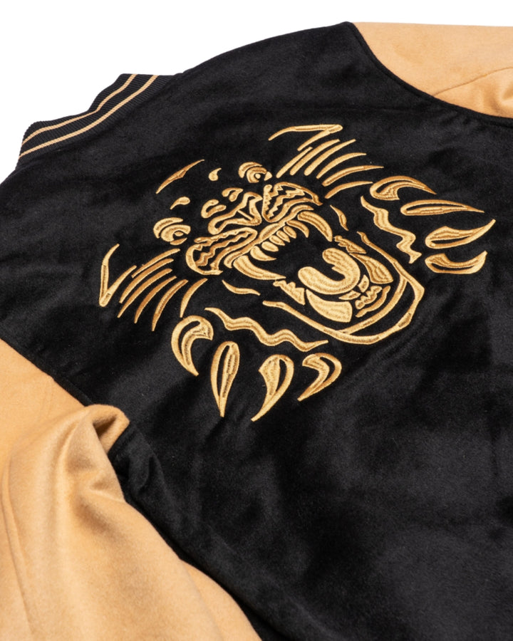 The Panthersland Nottingham Panthers Varsity Jacket Black/Gold 25-26 features a gold embroidered roaring tiger on the back, inspired by classic Panthers jacket styles.