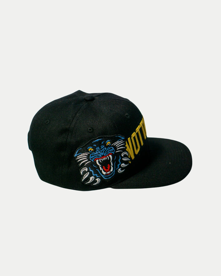 The Panthersland Nottingham Panthers 25-26 Big City Text Snapback Cap features a bold blue and black embroidered panther on the side and partially visible yellow text on the front.