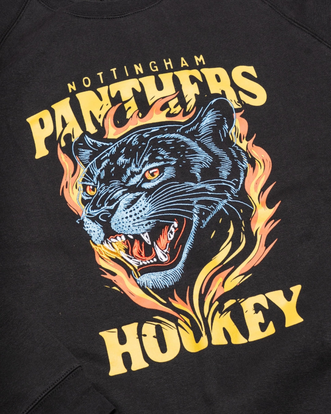 The Panthersland Nottingham Panthers Black Sweatshirt Large Print 25-26 showcases a bold flaming panther graphic and vivid yellow “Nottingham Panthers Hockey” lettering above and below the image.