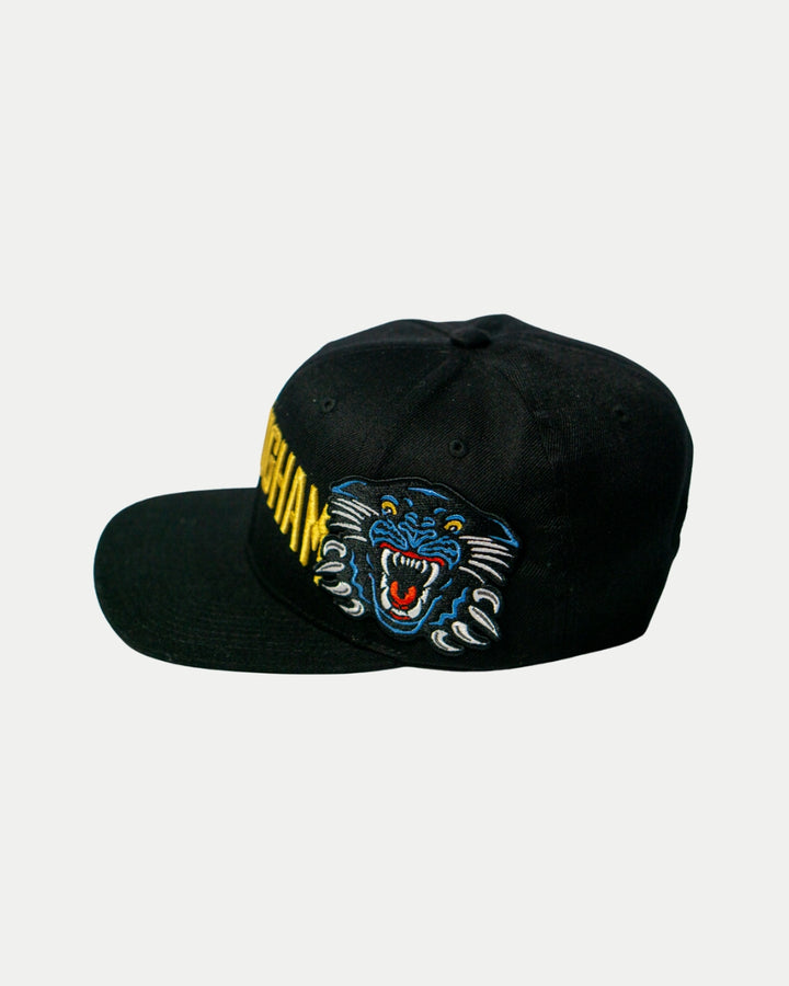 The Nottingham Panthers 25-26 Big City Text Snapback Cap by Panthersland features a bold black design with a colorful embroidered roaring blue panther on the front left panel and striking yellow text on the right side.