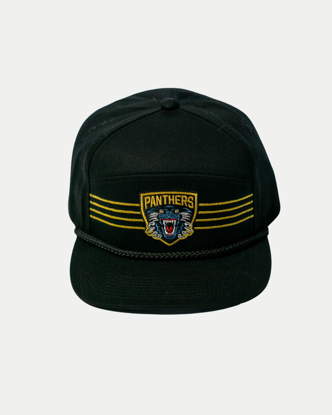 The Panthersland Nottingham Panthers 25-26 Four Stripe Flatbrim Cap is a black cap with a gold stripe, rope detail above the brim, and an embroidered snarling panther patch featuring PANTHERS on the front.