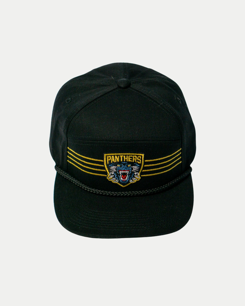 The Panthersland Nottingham Panthers 25-26 Four Stripe Flatbrim Cap is black with a gold stripe, braided rope on the brim, and an embroidered roaring panther crest on the front.