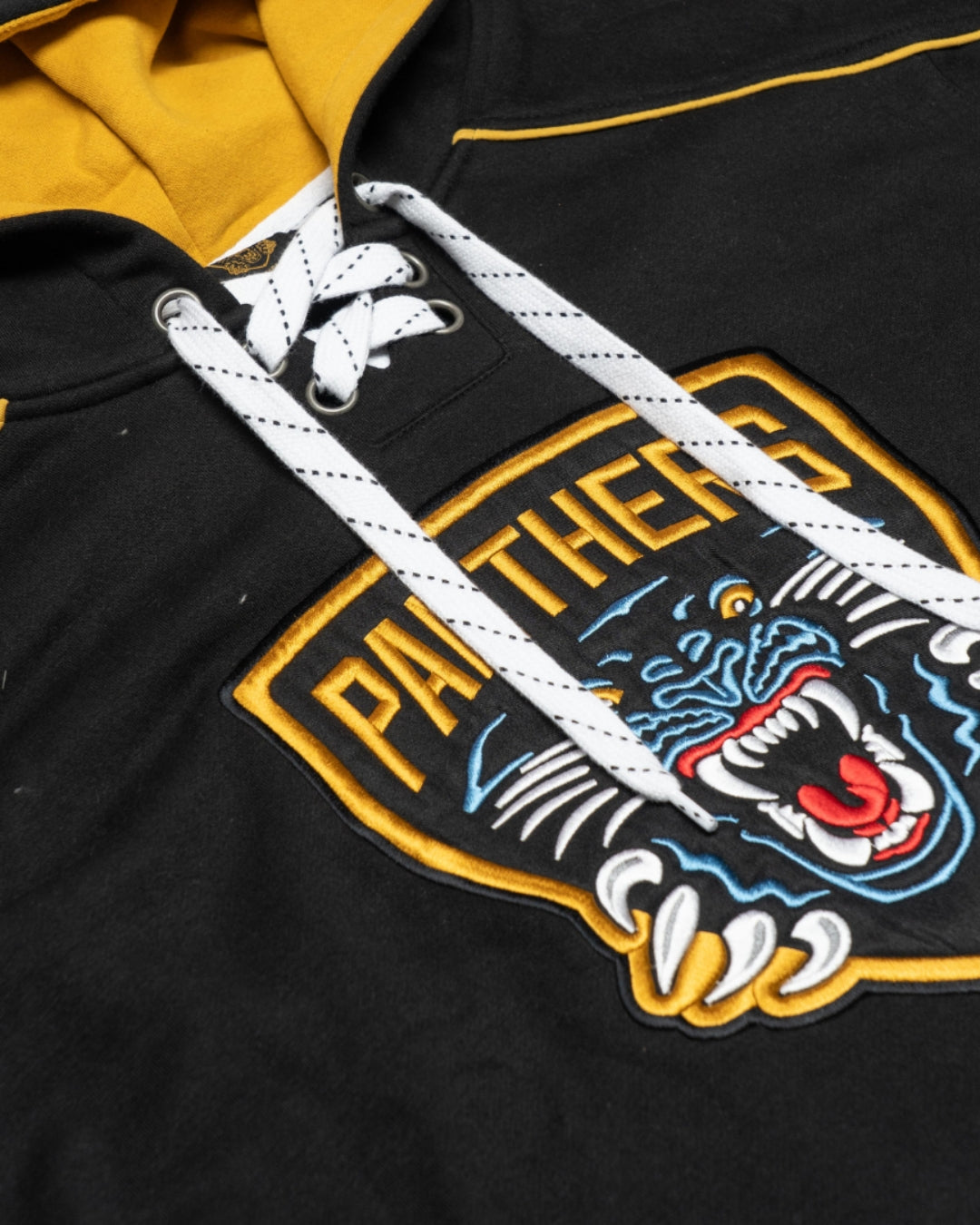 Close-up of the Nottingham Panthers Hockey Hoodie Striped by Panthersland, showcasing lace-up details, a yellow-lined hood, embroidered roaring panther logo, and bold yellow PANTHERS lettering.