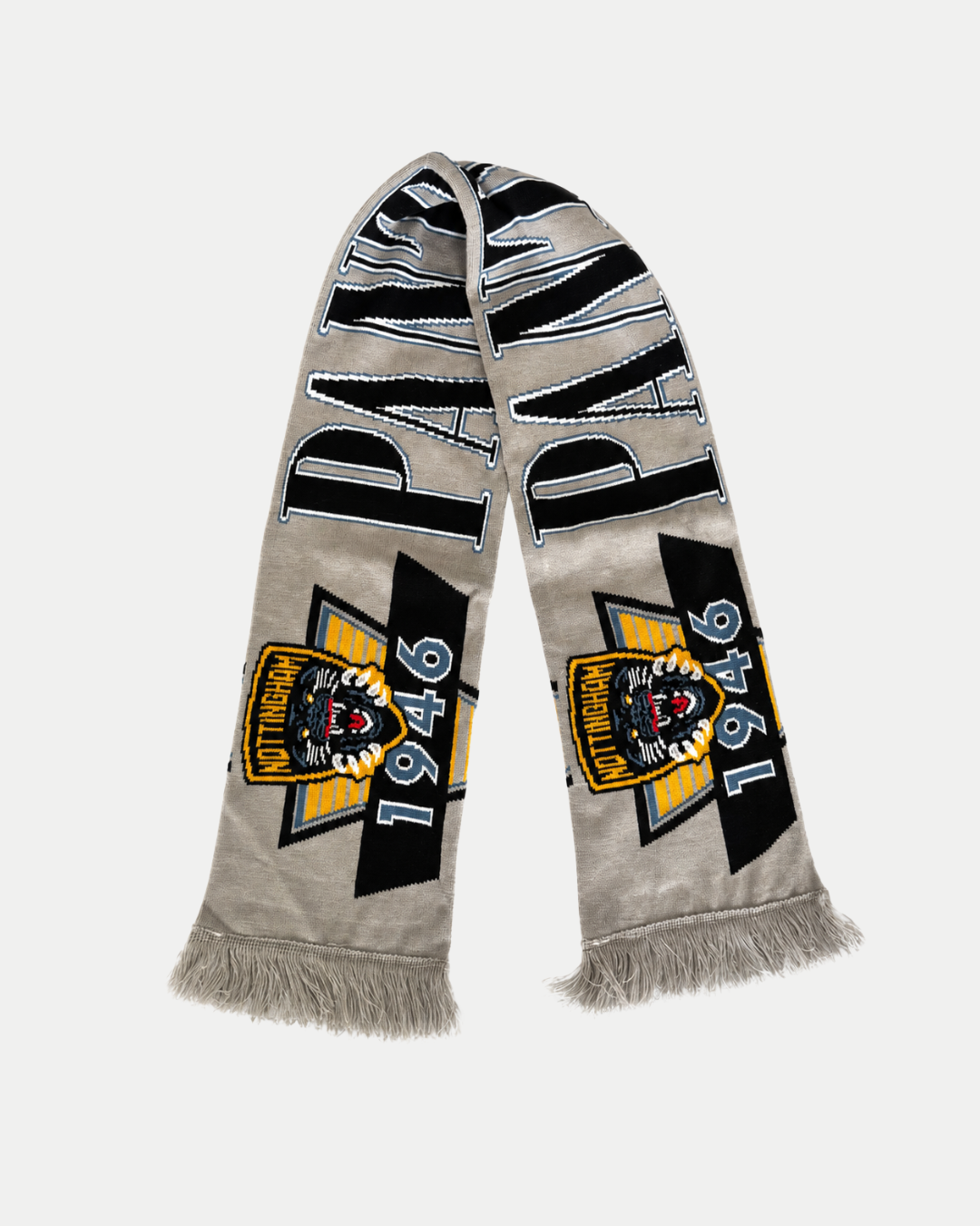 A nod to Pantherville heritage, the 26-27 Vintage Scarf by Panthersland is a vintage grey piece with fringe ends, showcasing a snarling tiger logo, the year 1946, and “PAOK” in bold letters—reminiscent of a classic Nottingham Panthers scarf.