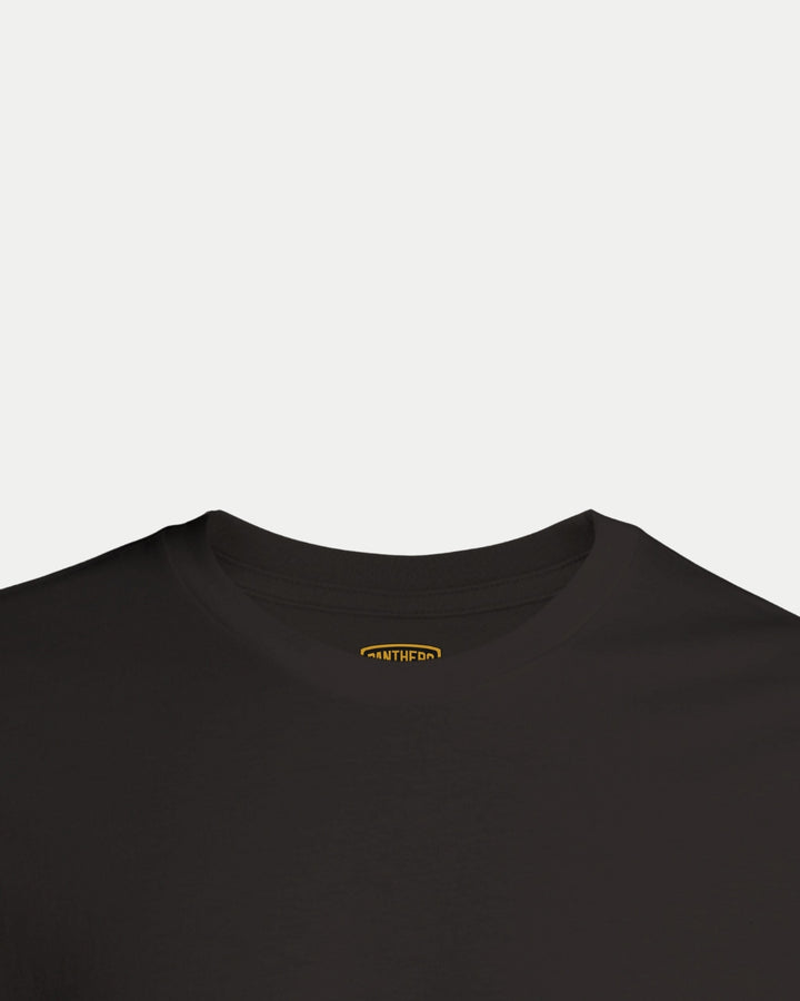 Close-up of the neckline on a Nottingham Panthers Made To Order Champions Elite League Playoffs 2025 T-shirt in black, showing a small yellow INNER label inside the collar against a white background.