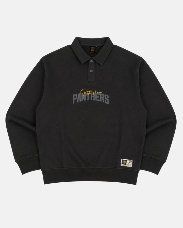The Panthersland 26-27 Black Tonal Sweater features a long-sleeve rugby-inspired design with a collared neckline, highlighted by gold “Panthers” lettering and signature embroidery on the front. A small rectangular label on the lower left hem adds a distinctive touch, making this sweater a standout choice for Nottingham Panthers fans.