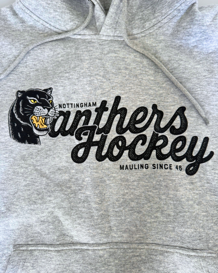 Display your team spirit with the 26-27 Grey Panther Hoodie from Panthersland. This grey hoodie features a bold graphic of a snarling black panther alongside the statement “Nottingham Panthers Hockey, Mauling Since 46” printed on the front—an ideal choice for any devoted Nottingham Panthers hockey fan.