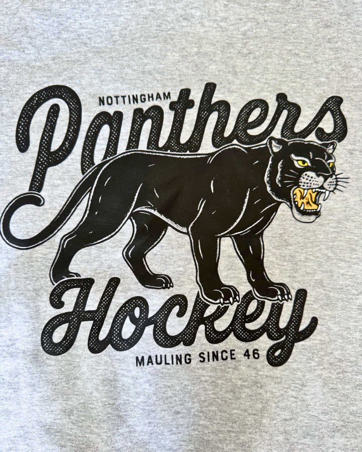 Show your support for Panthers Hockey with the Panthersland 26-27 Grey Panther Hoodie. Featuring a black panther graphic baring its teeth and the text “Nottingham Panthers Hockey Mauling Since 46,” this design is perfect for fans. Also available as a classic grey shirt.